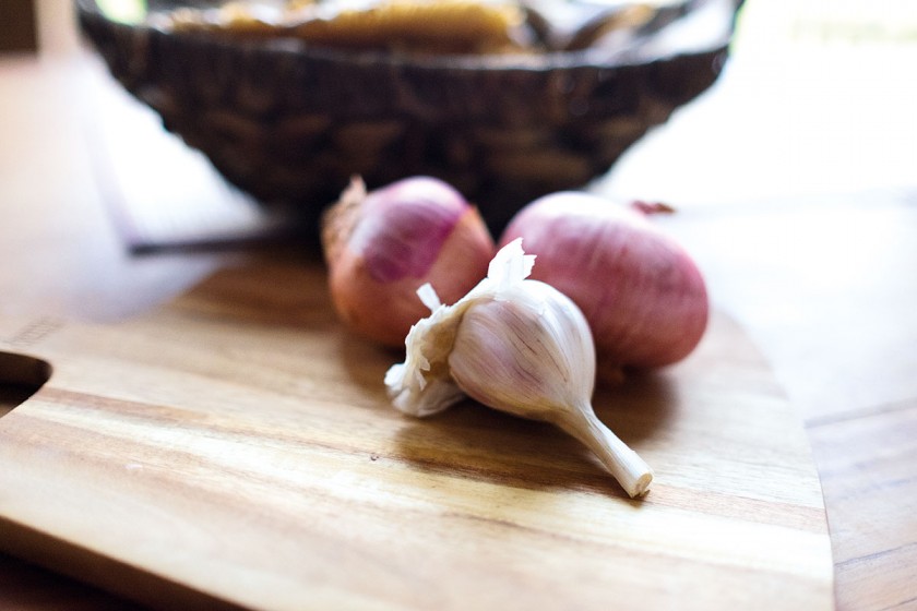 Knoblauch und Zwiebeln zum Lammbraten geben